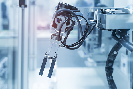 A mechanical arm in action, set against an industrial background