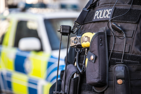 Police officer stands in front of police vehicle