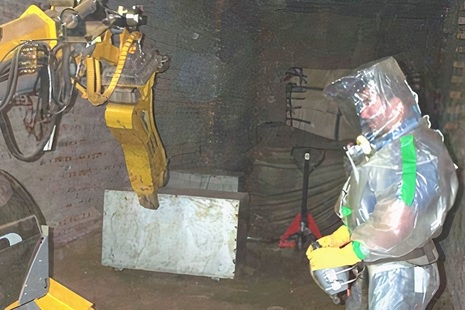 Worker in protective suit sorts through waste
