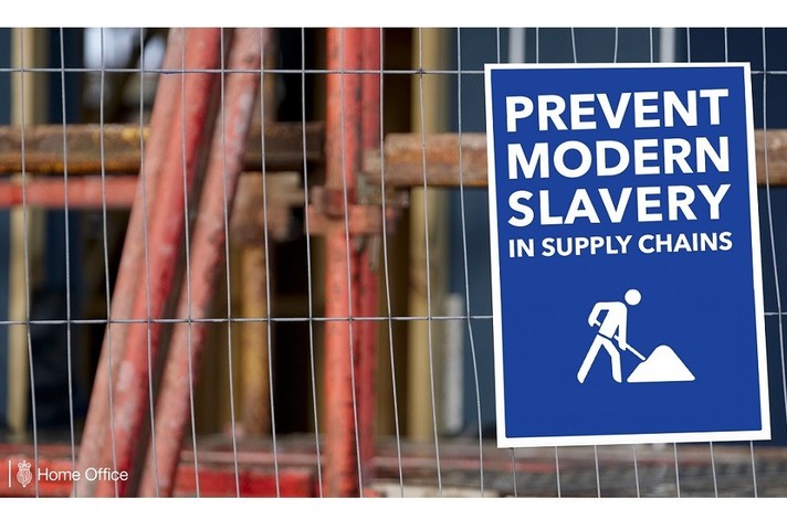 Sign on a fence reading "Prevent modern slavery in supply chains"