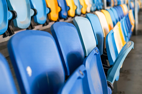 Image of multicoloured seats in sports stadium