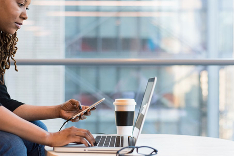 Female business professional working at laptop and phone