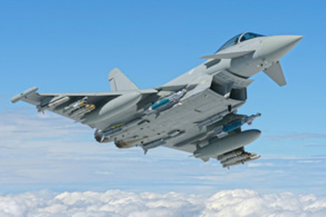 Typhoon in full profile flying against a blue sky.