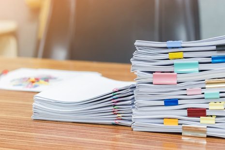 A pile of exam papers on a desk