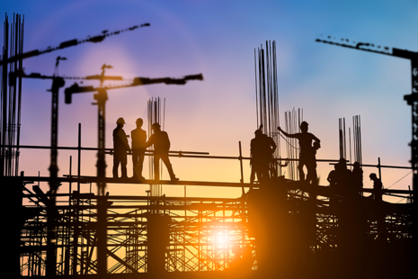 Sunlit silhouette of a construction team working at a construction site
