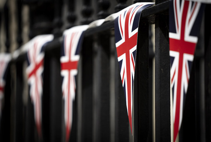 5 triangular Union Jack flags hanging on some railings