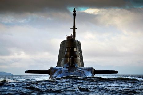 A nuclear submarine at sea with just the top of the submarine seen out of the water.