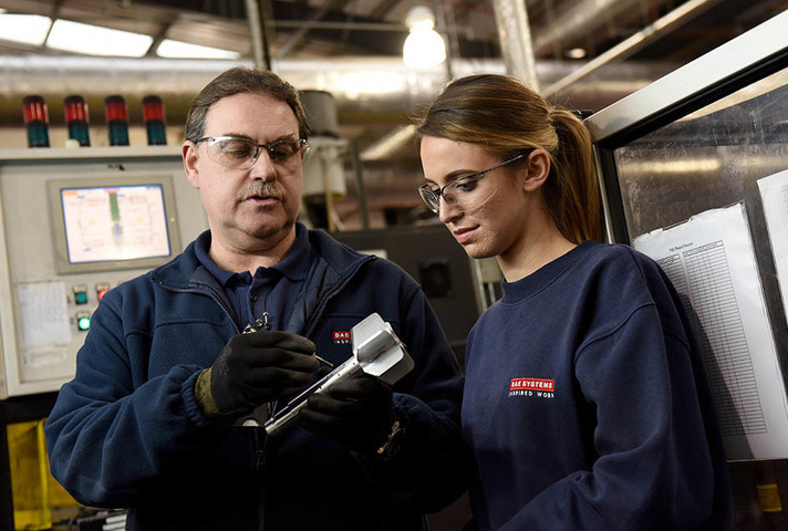 A man and a woman look at a shell they are working on.