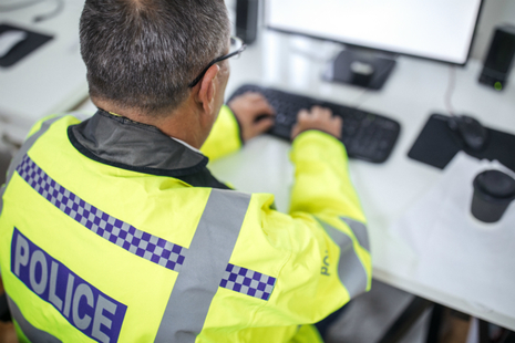 Police officer using a computer