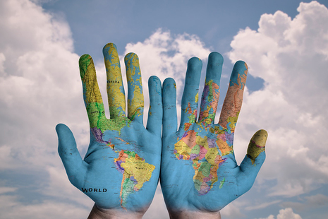 World map painted on a pair of hands