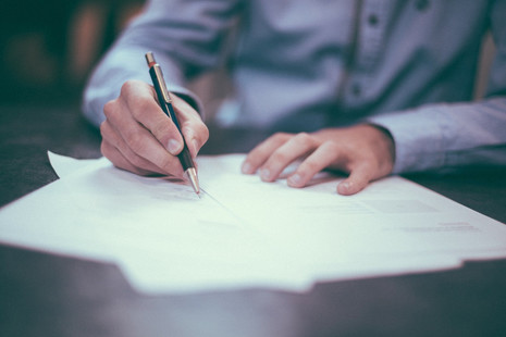 A man writing documents on paper