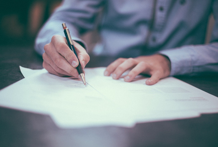 A man writing documents on paper