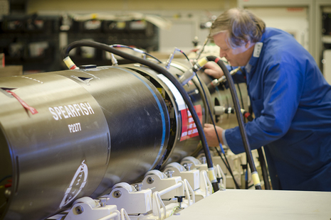 Image depicts a man working on a Spearfish torpedo.