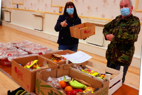 Man and woman with boxes of food including vegetables