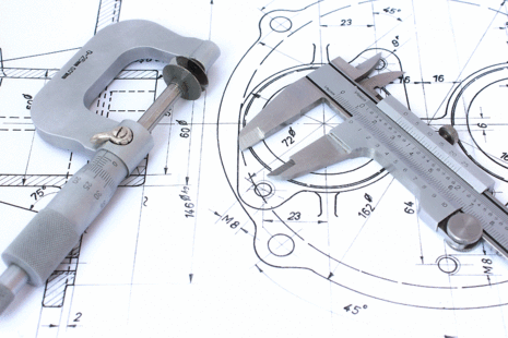 Precision measuring instruments on a technical engineering drawing.