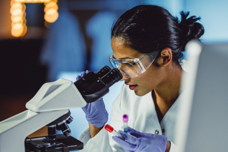 Scientist looking into microscope