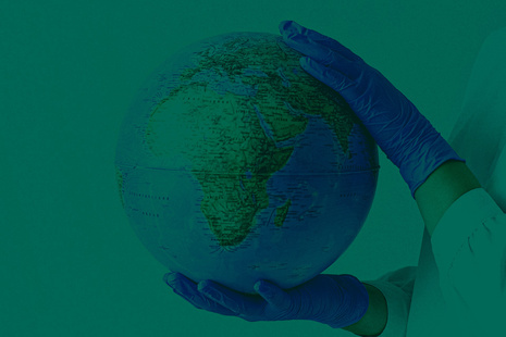 gloved hands holding a globe