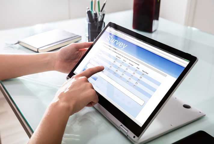 Someone using a tablet touchscreen to fill out an online survey.