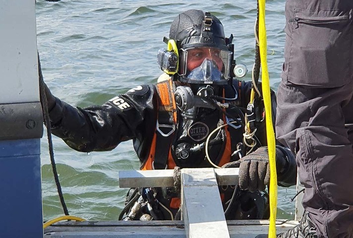 Diver emerging from water and climbing onto boat