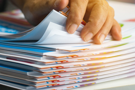 Exam papers stacked on a desk.
