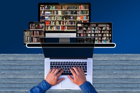 Image of hands on computer keyboard with shelves full of files in background