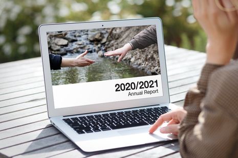 Persons hands typing on a laptop
