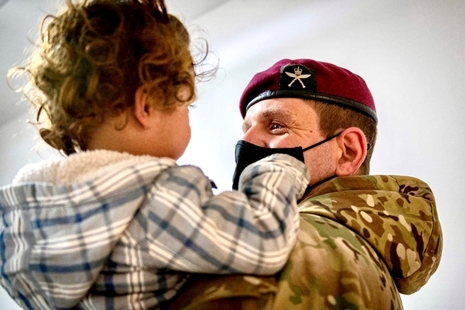 Commanding Officer First Battalion The Royal Gurkha Rifles holds an Afghan evacuee