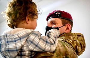 Commanding Officer First Battalion The Royal Gurkha Rifles holds an Afghan evacuee
