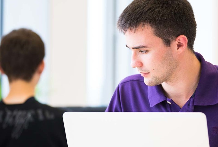 Male student studying using a laptop