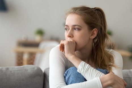 Girl sitting on a couch, looking anxious