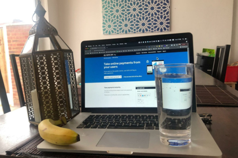 A banana and glass of water rest on a laptop.