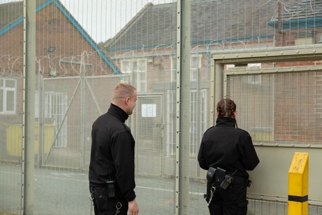 Офицер тюрьмы открывает ворота