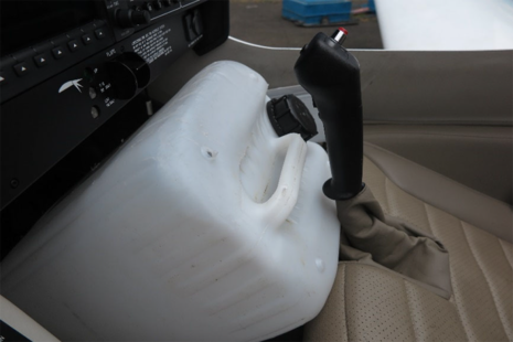 Figure 8 De-icing fluid container positioned at an angle with its base in contact with the rudder pedal adjustment