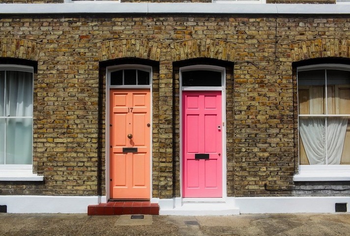 Image of two doors on a street of terraced houses.