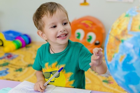 young toddler looking at a globe