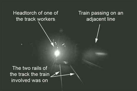 Forward facing CCTV from train approaching trackworkers on the line at night near Penkridge, Staffordshire