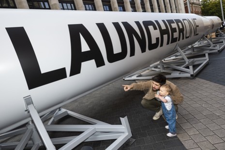 Man and boy pointing at LauncherOne rocket