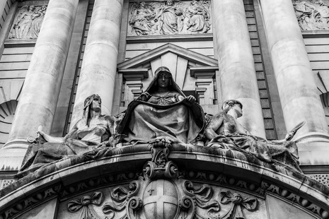 Statue of the Recording Angel above the main entrance to the Old Bailey flanked by Fortitude and Truth.