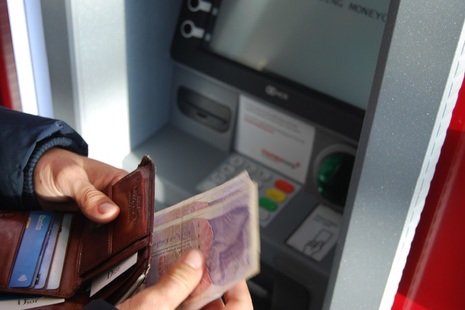 Person taking money from a cash machine.