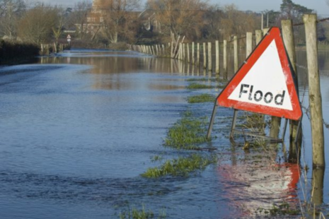 Image of flooded road with sign warning of danger