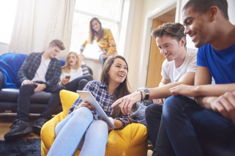 A group of young people talking and laughing. 