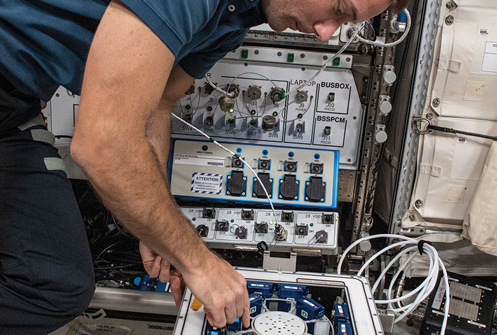 ESA astronaut Thomas Pesquet inserting 24 experiment units in the KUBIK incubator on the International Space Station.