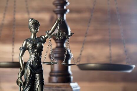 A metal statue of Lady Justice holding balancing scales.