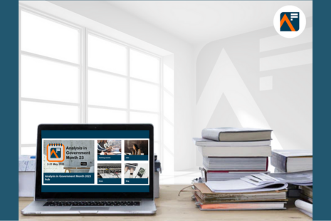 Стол с книгами и ноутбуком, на котором отображается домашняя страница веб-сайта функции анализа.
