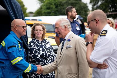 Король Чарльз обменивается рукопожатием с членами береговой охраны во время визита в Девон в рамках празднования 200-летия береговой охраны.