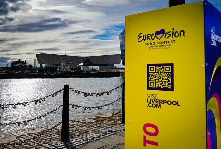 Вид на доки Ливерпуля со знаком Евровидения на переднем плане и ареной, где проходит конкурс по воде.