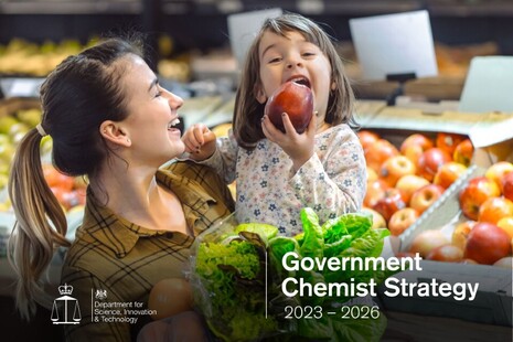 Женщина с ребенком на руках ест яблоко.  В тексте говорится: «Стратегия правительства в области химии на 2023–2026 годы».