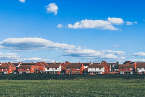 A row of houses beyond a field