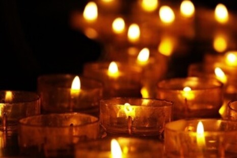 Candles glowing against a dark setting.