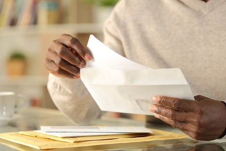 A person taking a letter out of an envelope  